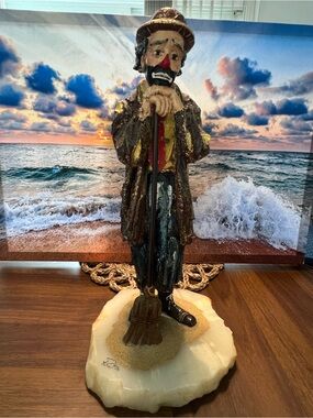 Hobo clown with a broom sweeping. 
Made by Ron Lee whiskers sweeping.